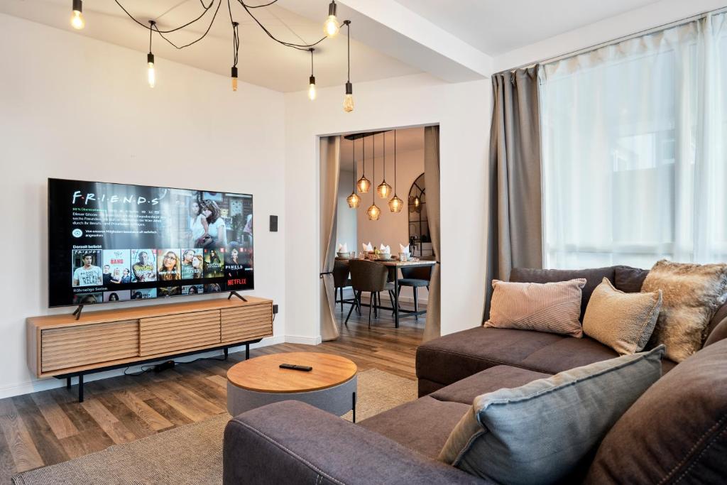科隆Park Avenue - Design Apartment Friesenstraße - 4 Pers - WLAN - Netflix - 65 Zoll TV的带沙发和平面电视的客厅