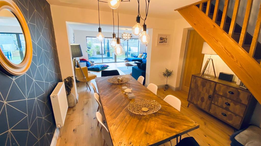 圣艾夫斯Tregenna House - St Ives, A Beautiful Newly Refurbished 4 Bedroom Family Town House With Alfresco Dining Garden and Private Parking Spaces的一间带木桌的用餐室和一间客厅。