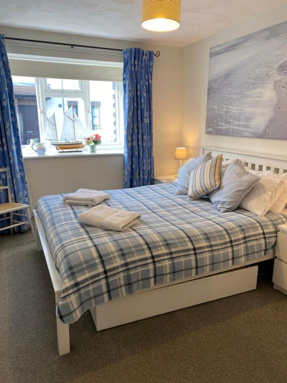 海景城Lovely 3 bed ground floor flat with garden, close to the beach, dog friendly的一间卧室配有一张带铺着地毯的床和窗户。