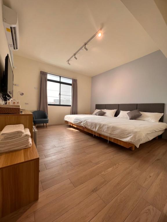 茄萣路科民宿的一间卧室配有一张大床和电视