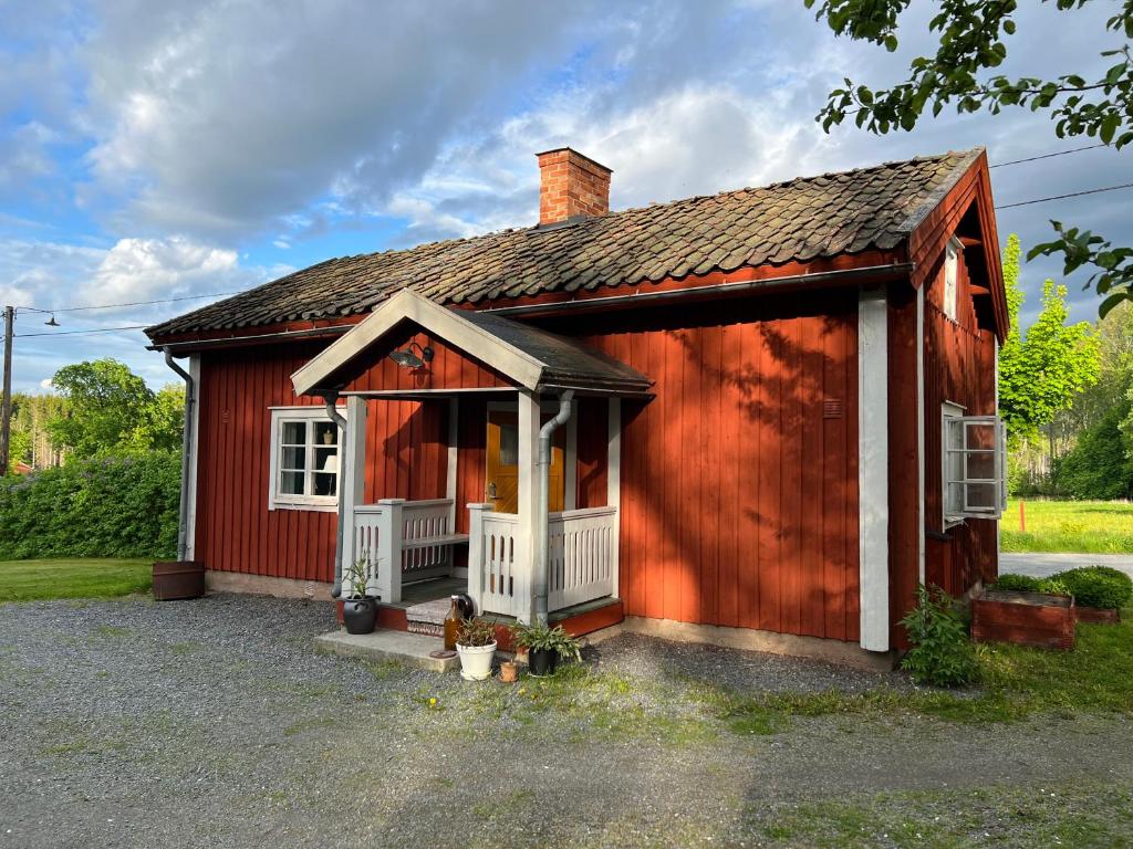 诺拉Lilla Backstugan的一间红色的小房子,设有白色门廊