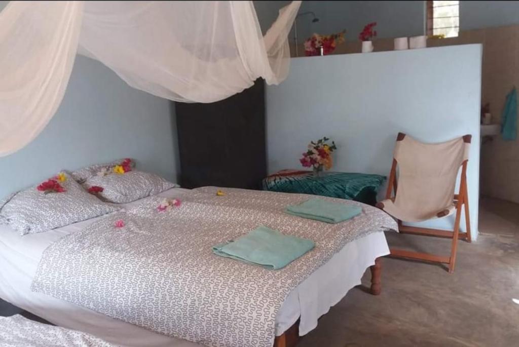 AbéméAbenebolong的一间卧室配有一张床,上面有两条毛巾