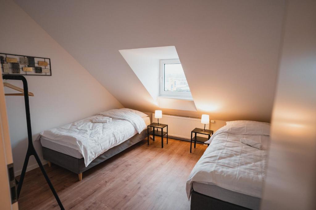 门兴格拉德巴赫Working Apartment - 8 single beds - 5 Schlafzimmer的阁楼卧室设有两张床和窗户。