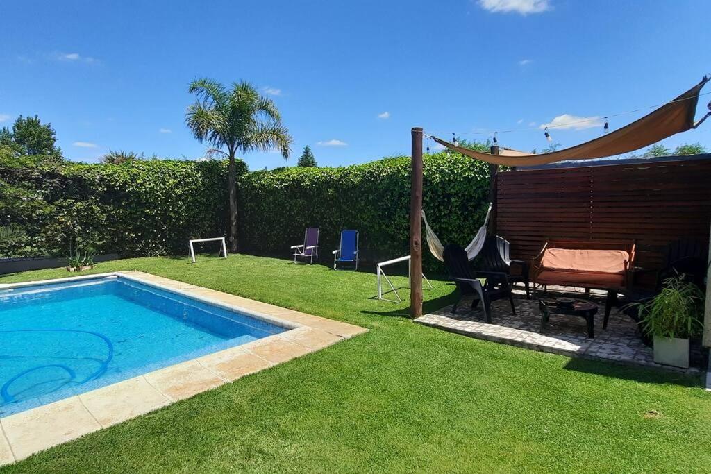 圣罗莎Casa quinta con pileta的后院设有游泳池和桌椅