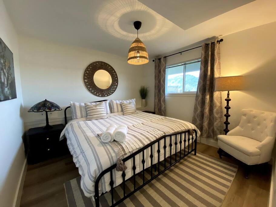 维多利亚Cozy Lakeview Suite的卧室配有床、椅子和窗户。