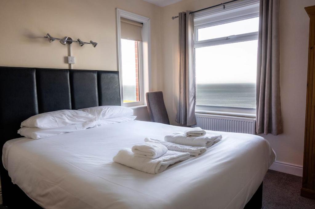 惠特比威尔戴尔旅馆的一间卧室配有一张带毛巾的床,设有窗户