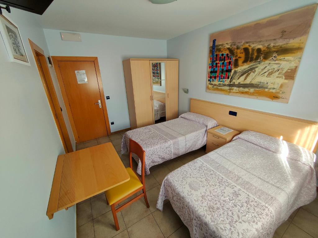San Miguel de MerueloHostería Sol的酒店客房设有两张床和一张桌子。