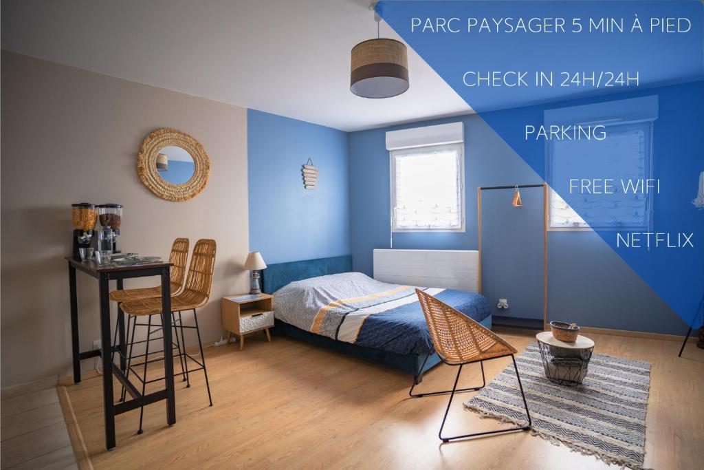 圣纳泽尔L'Effet-Mer - Tout équipé - Parking Privé - Wifi的一间拥有蓝色墙壁的卧室,配有一张床和一张桌子