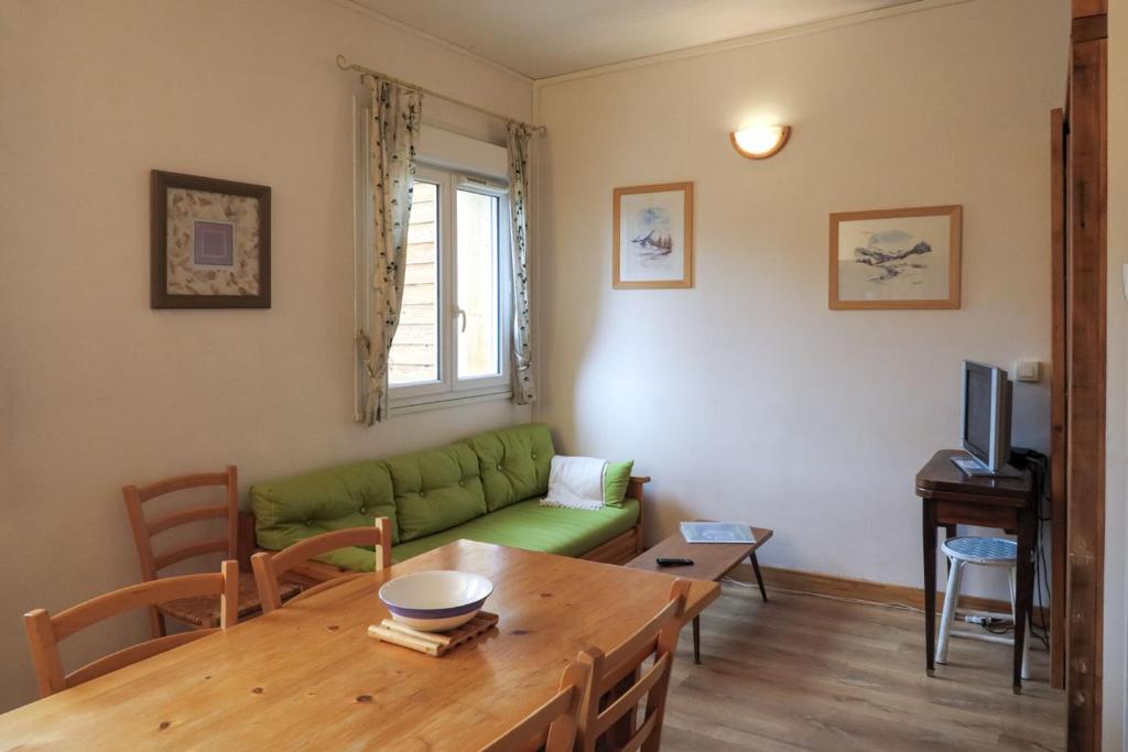 奥特朗Gîte CAMPANULES - 5 personnes - "Les Gites du Chalet" à Autrans的客厅配有绿色沙发和桌子