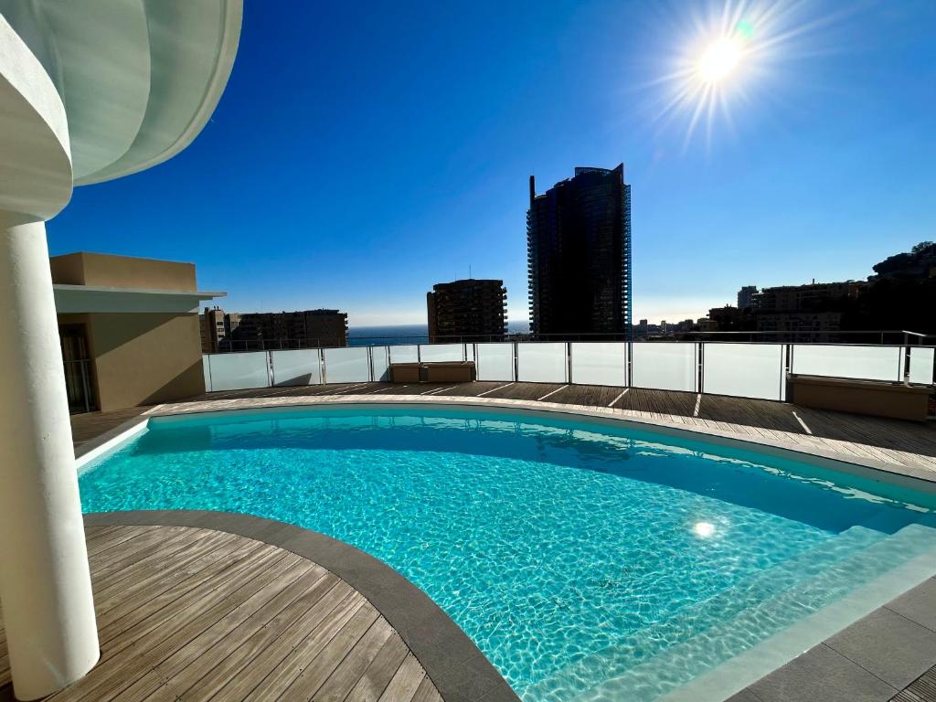 蒙特卡罗Luxueux Studio Neuf - Frontière Monaco - Piscine - Parking privé的建筑物屋顶上的游泳池