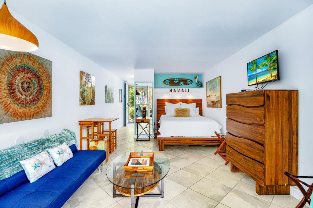 科纳DOWNTOWN HAWAIIAN PARADISE HOTEL CONDO with Hot Tub, Pool & Beach的客厅配有床和蓝色沙发