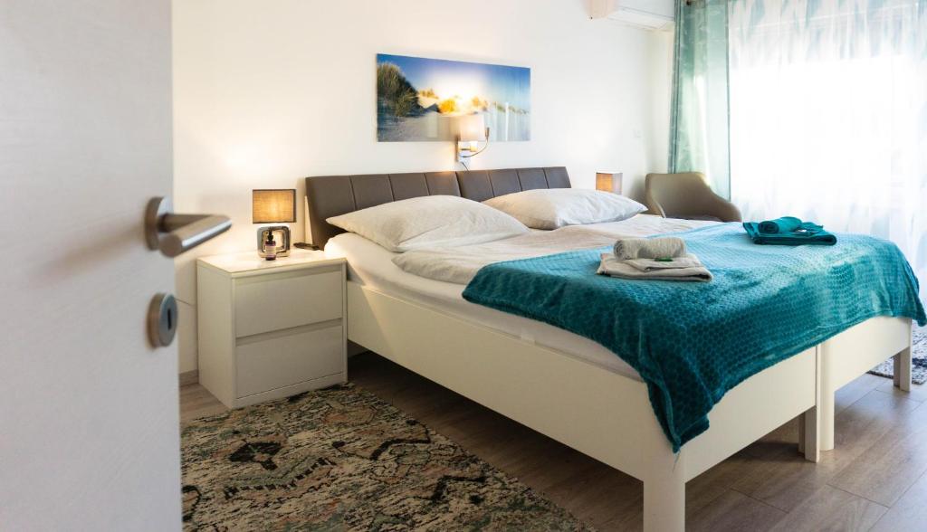 巴特塔茨曼斯多夫Baum Apartments的一间卧室配有一张带蓝色毯子的床