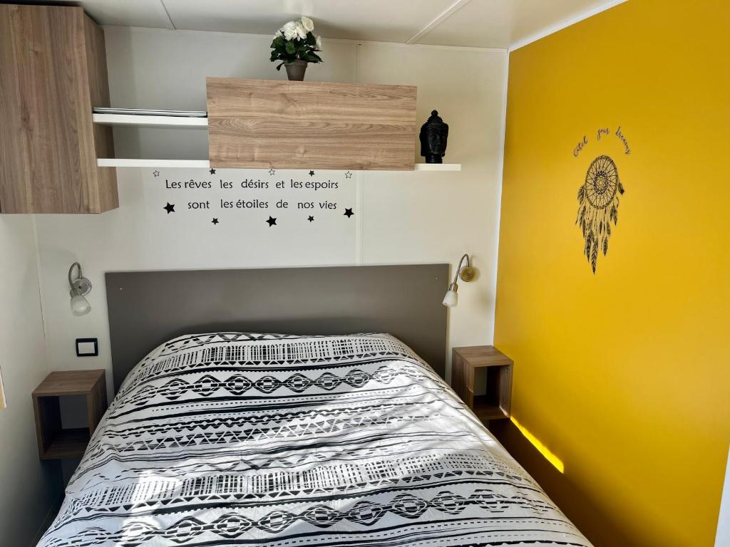 弗雷瑞斯Mobile home Zen Siblu Fréjus的一间卧室设有一张床和黄色的墙壁