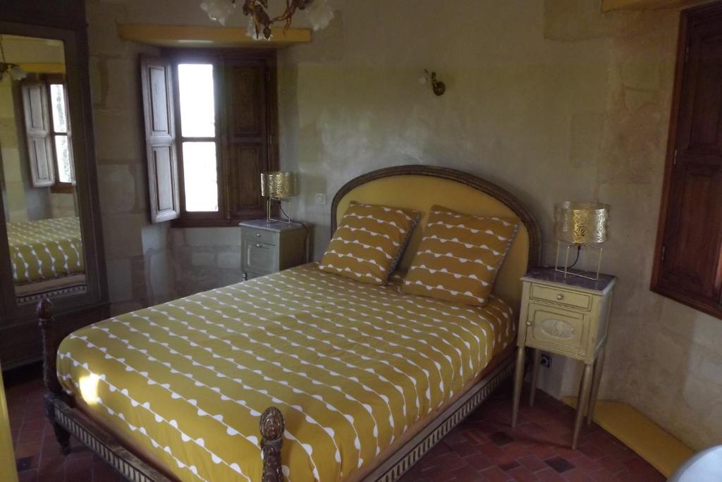 索米尔Chambres d'hôtes La Tour de Bellevue的一间卧室配有床、两张桌子和镜子