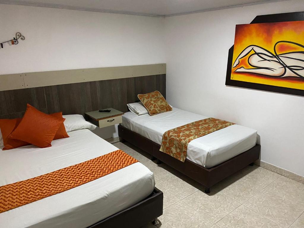 金巴亚Finca Hotel San Angello的酒店客房设有两张床,墙上挂有绘画作品
