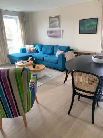 伦敦2 Bedroom Chelsea Apartment的客厅配有蓝色的沙发、桌子和椅子