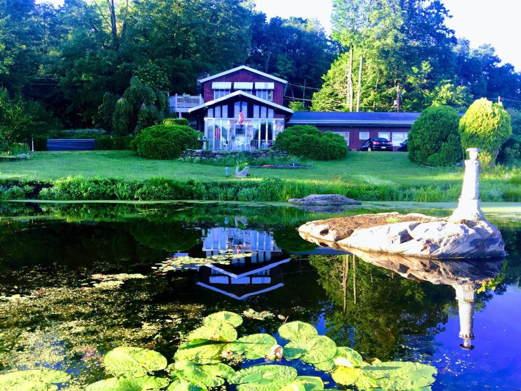 LakevilleLake Moc A Tek Inn的前面有天鹅的房子和池塘