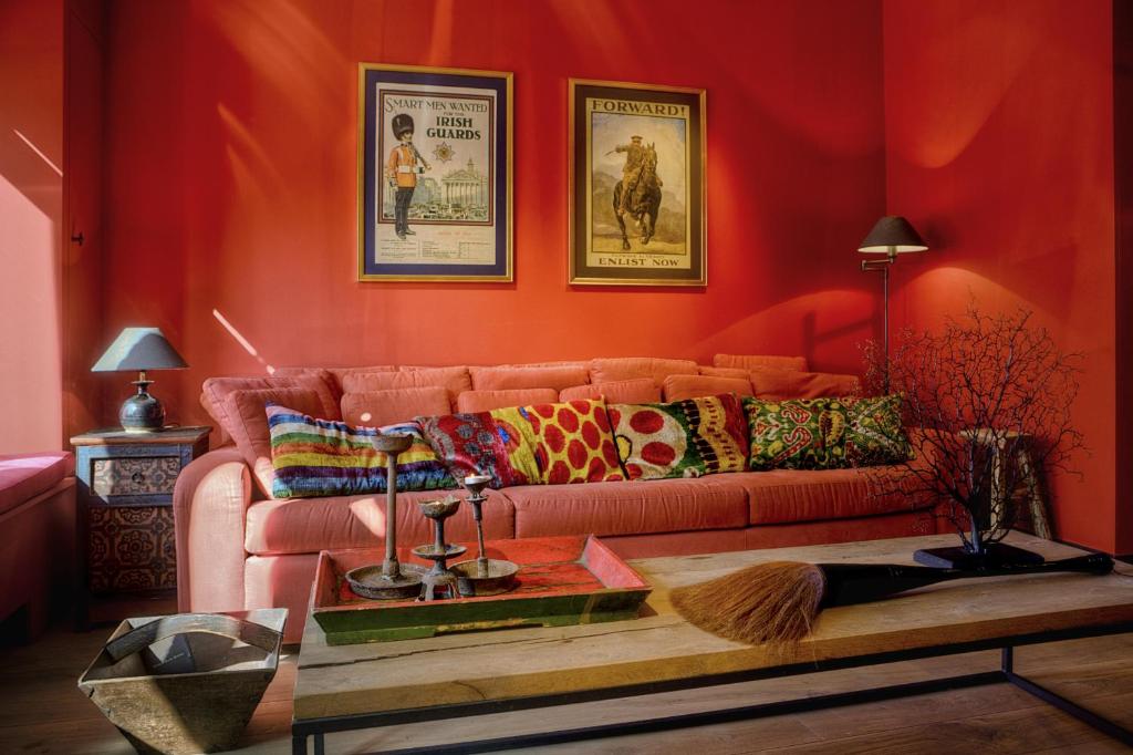 伊普尔Menin Gate House的客厅配有红色墙壁内的粉红色沙发
