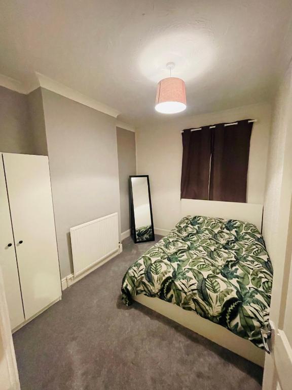 纽波特Shou’s guest house的一间卧室配有一张床和镜子