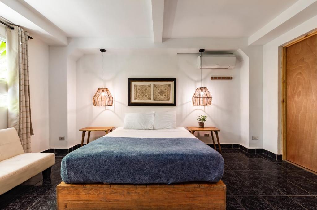 圣萨尔瓦多Cinco Hotel B&B的一间卧室配有一张床、两张桌子和两盏灯。