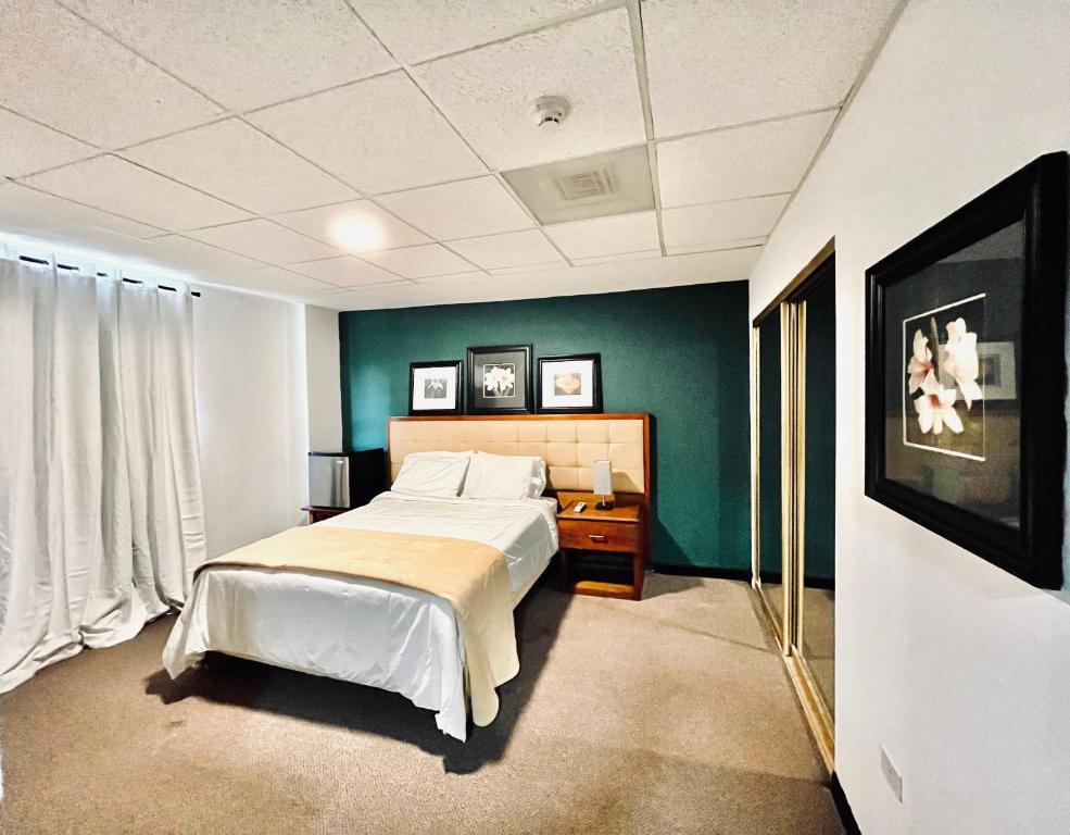圣胡安SJ SUITES HOTEL的一间卧室设有一张床和绿色的墙壁