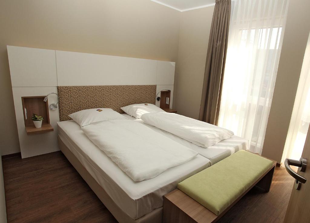 明斯特Hotel Bakenhof的一间卧室设有两张白色的床和窗户
