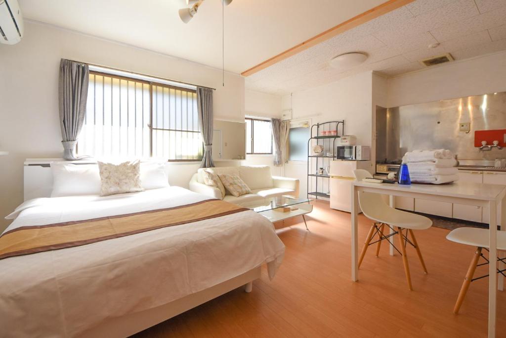 奈良舒适住宿 MR1&MR2的一间带一张床和一张书桌的卧室和一间厨房