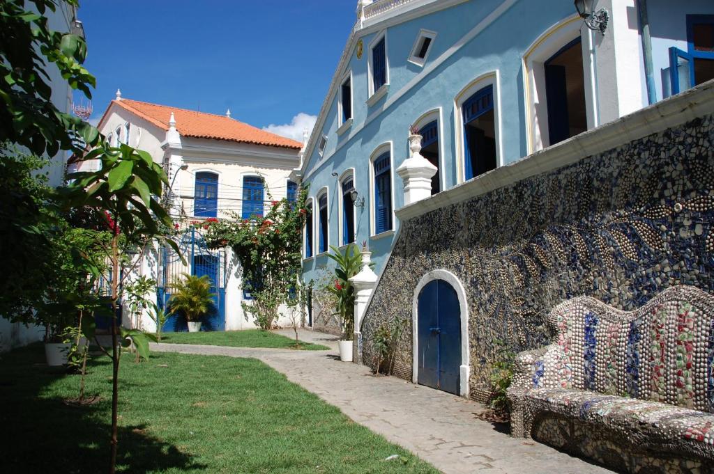 萨尔瓦多巴洛克巴伊亚酒店的蓝白色的建筑,前面有长凳
