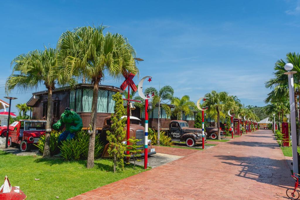 Ban Tao ThanApinya Resort Bangsarey的公园里一条有汽车和棕榈树的街道
