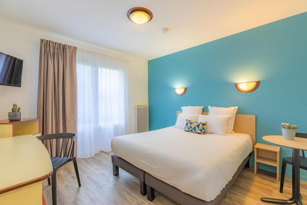 凯恩Appart'City Classic Caen的酒店客房配有一张床铺和一张桌子。