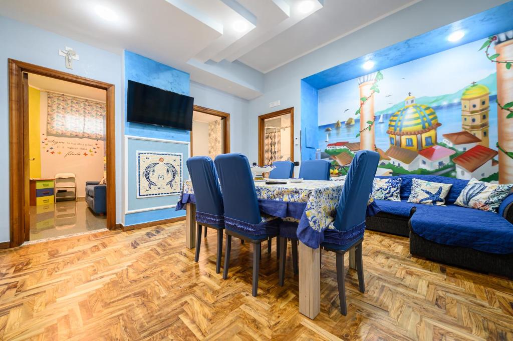 维耶特里Casa Maggio的一间带桌子和蓝色椅子的用餐室
