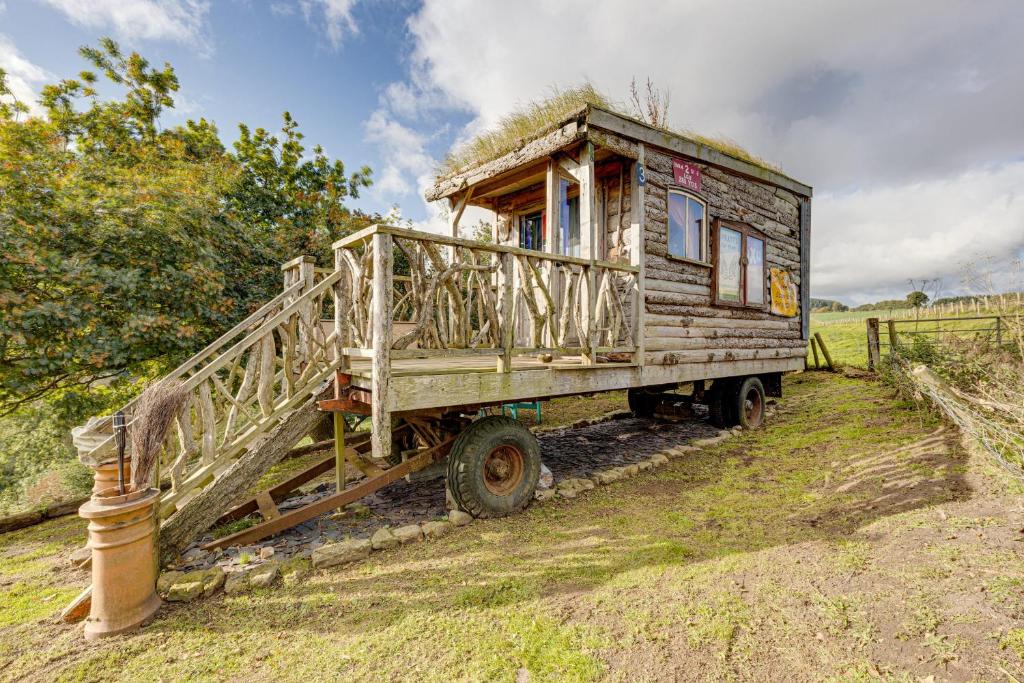 斯卡伯勒2x Double Bed - Glamping Wagon Dalby Forest的一辆旧木车,背面有房子