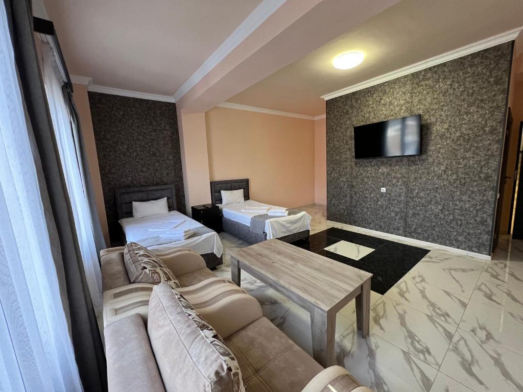 埃里温RP HOTEL (NEW)的酒店客房设有两张床、一张沙发和一张桌子。
