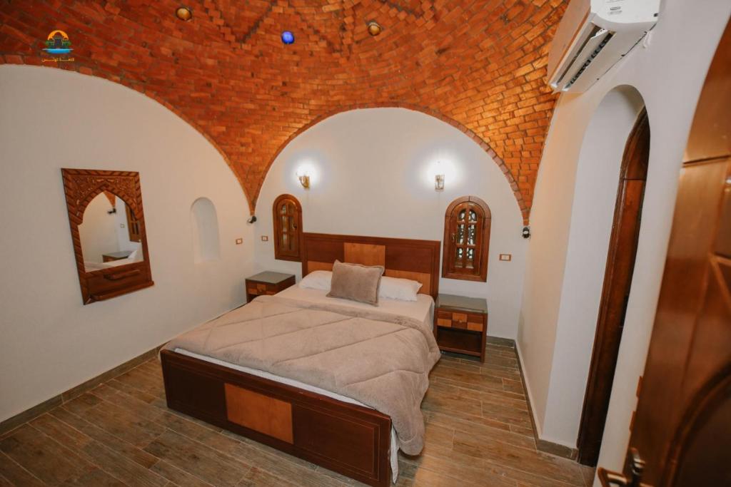 法尤姆Tunisia Castle Motel的一间带一张床铺的卧室,位于带拱门的房间