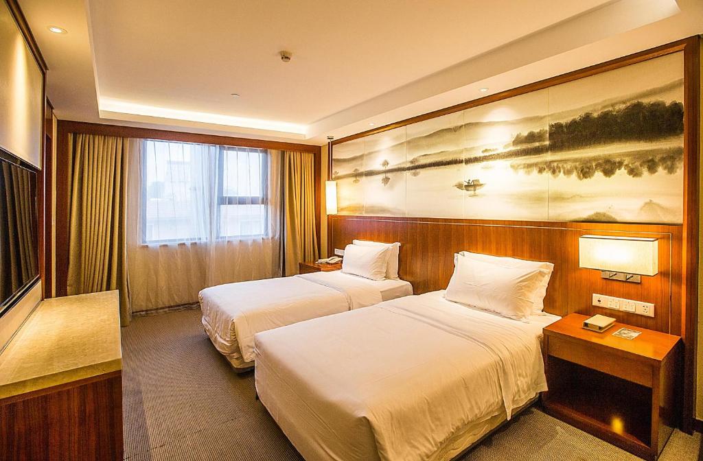 南京南京新街口王府大街亚朵酒店的酒店客房设有两张床,墙上挂有绘画作品