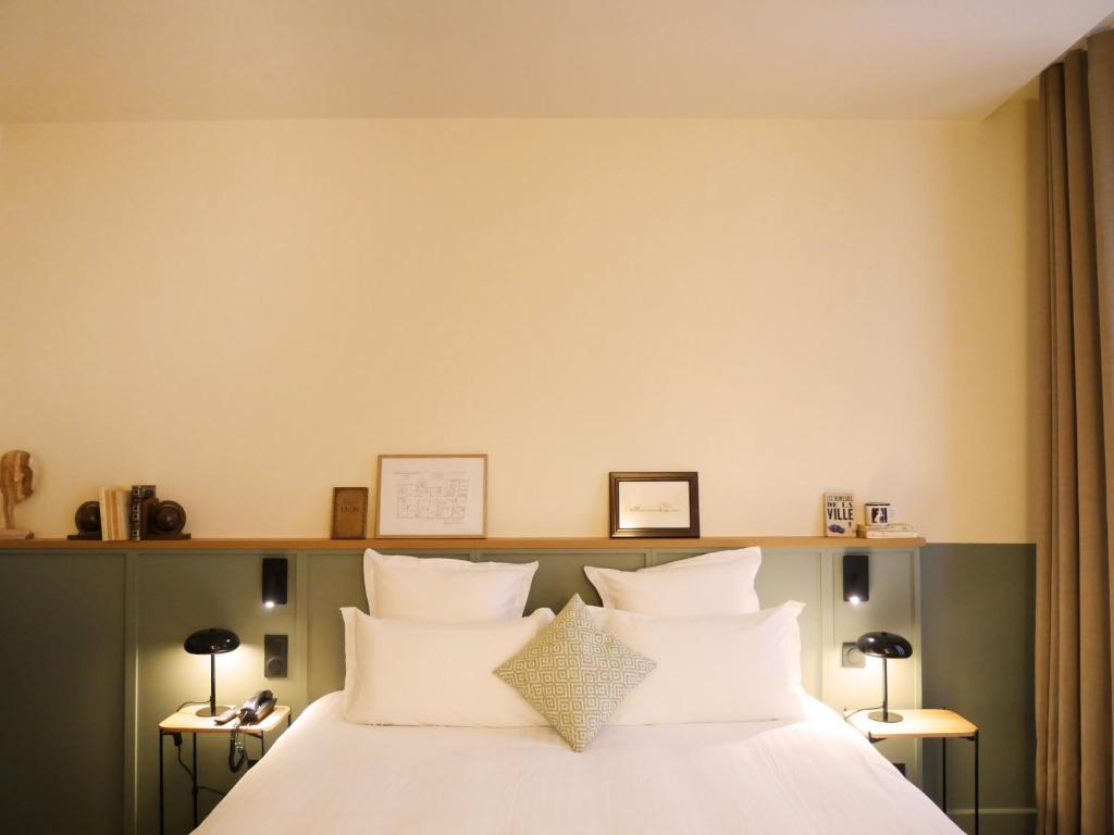 里昂全球塞西尔酒店的一间卧室配有带白色床单和枕头的床。