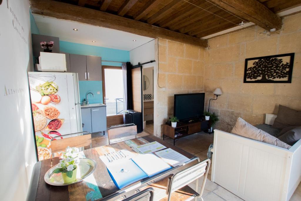 阿尔勒Ateliers, Terrasse - Parking - Clim的一间带桌子的客厅和一间厨房