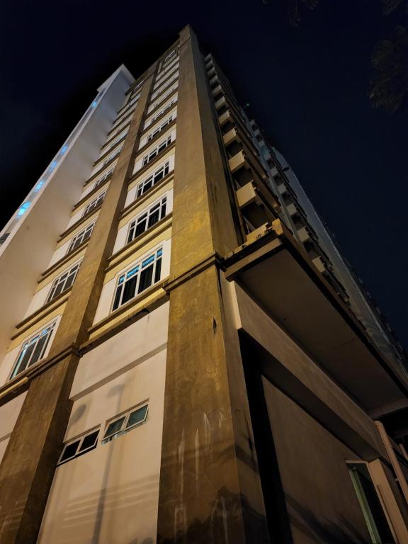 哥打巴鲁The Viana Apartment 1的一座高大的建筑,其门在晚上打开