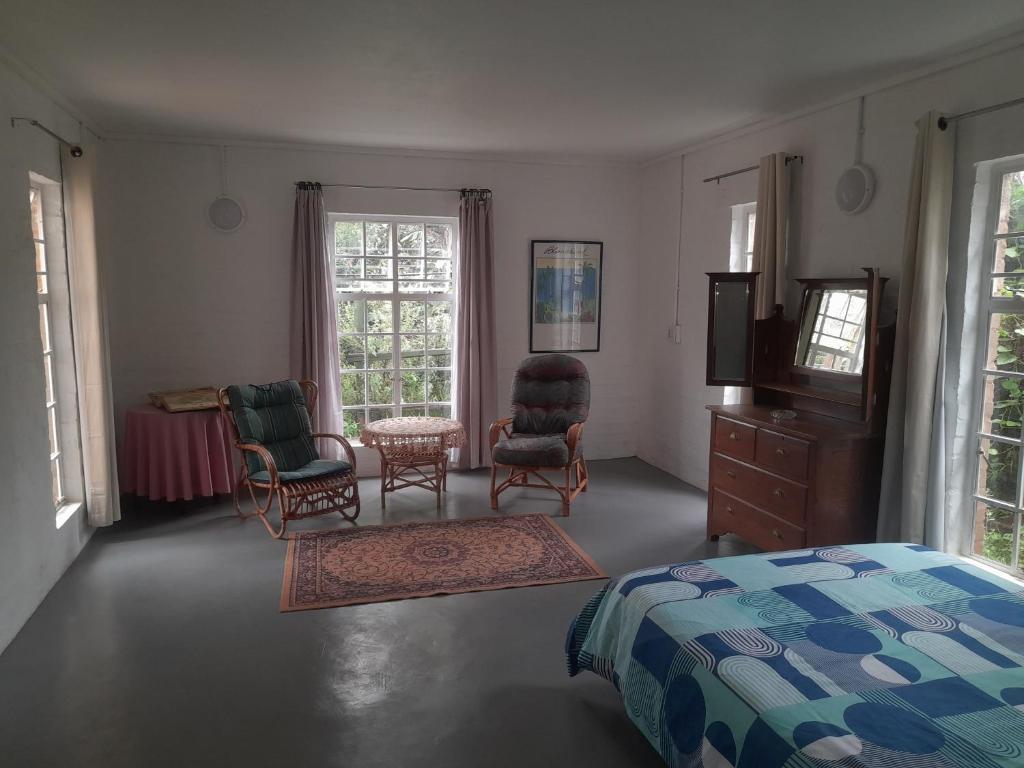 FloridaOorslaap的一间卧室配有一张床、两把椅子和一台电视