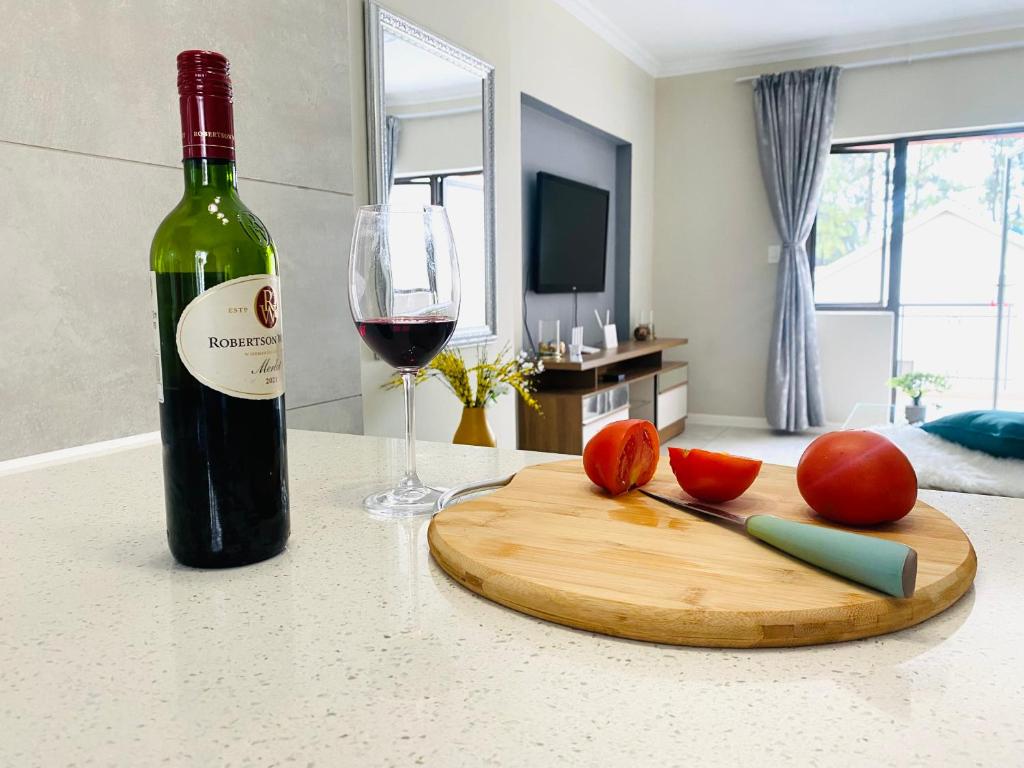 SandtonAt Home的一瓶葡萄酒、一把刀和一杯葡萄酒