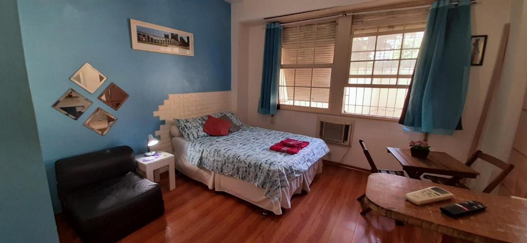 里约热内卢Sweet Studio Lapa的一间卧室配有一张床、一张沙发和一个窗口