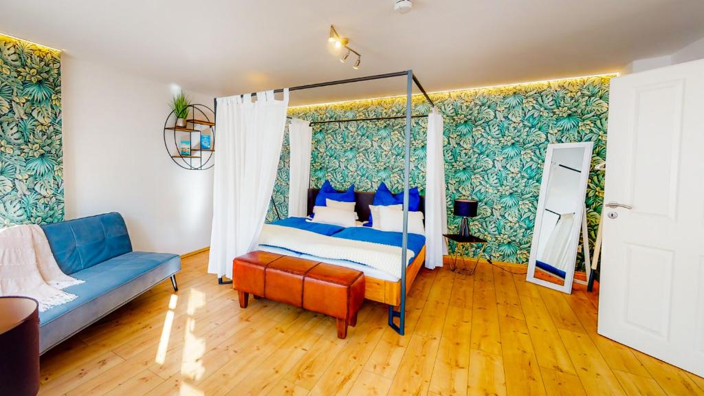 帕绍Alte Schmiede的一间卧室配有天蓬床和沙发