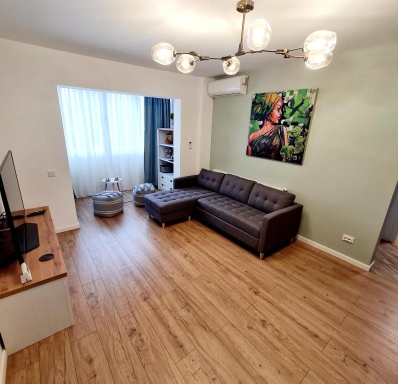 克卢日-纳波卡Eden Apartment的客厅设有黑色真皮沙发和木地板