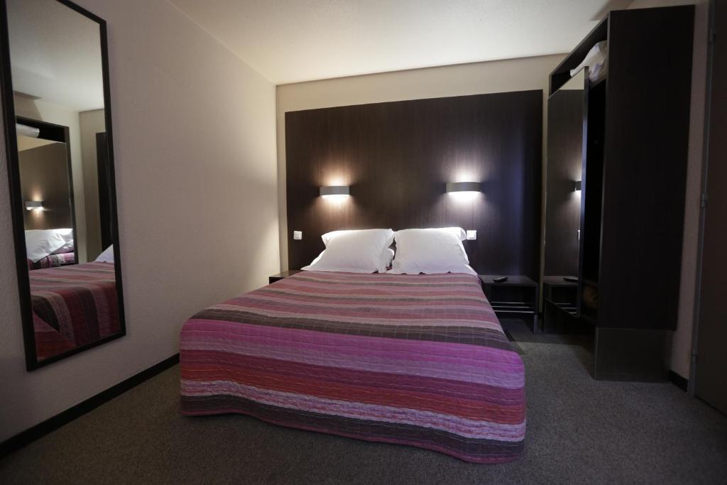 迈松阿尔福贝蒂卡波拉酒店的酒店客房设有一张大床和条纹毯子