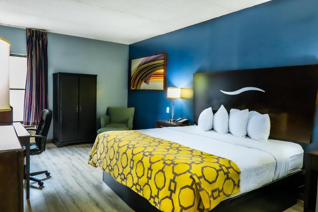 伦敦Baymont by Wyndham London KY的酒店客房设有一张带黄色毯子的大床