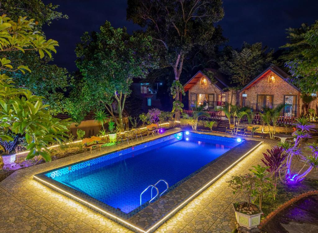 吉婆岛Cat Ba Spring Garden Homestay的夜间在房子前面的游泳池