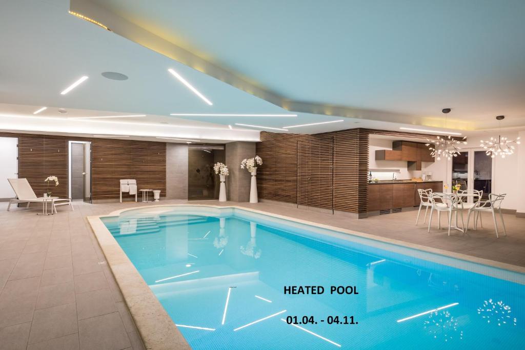 洛夫兰Plage Lovran Residence的一个带厨房和用餐室的大型游泳池