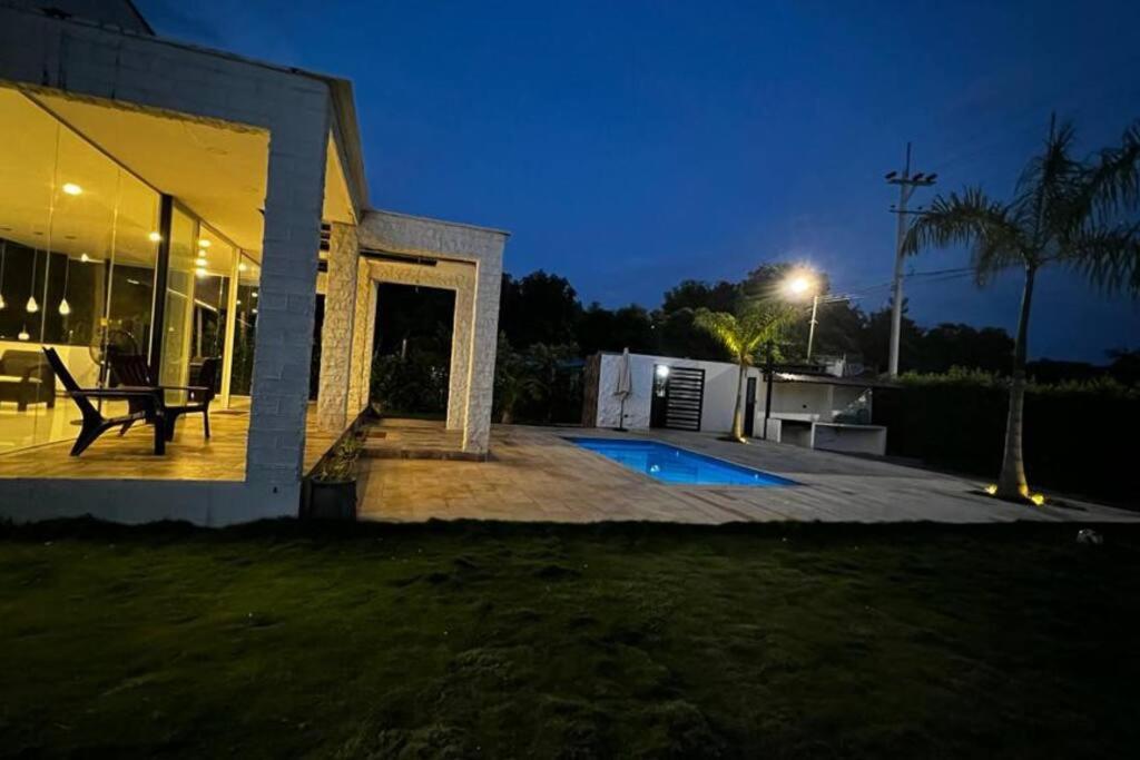 吉拉尔多特¡Quinta al Cielo!的一座带庭院的房子,晚上设有一个游泳池