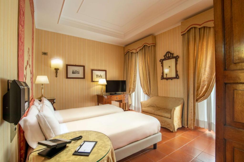 罗马Hotel Canada, BW Premier Collection的配有一张床和一把椅子的酒店客房