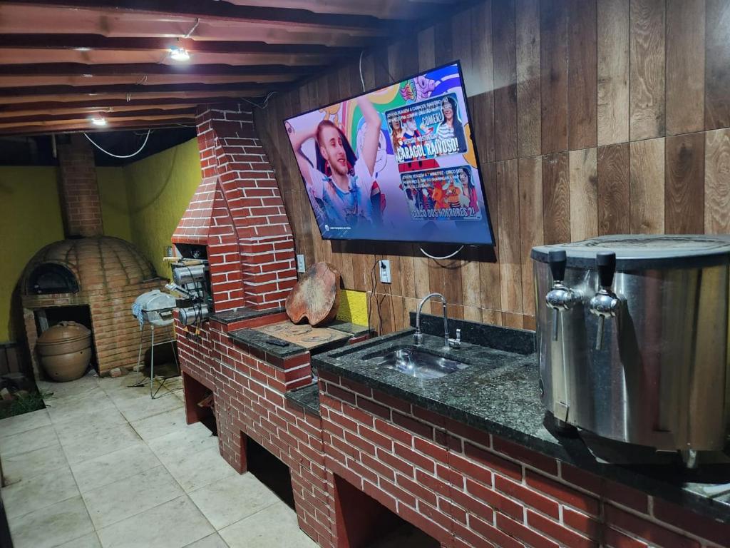里约达欧特拉斯POUSADA FLOR DO CARIBE的一个带水槽的厨房和墙上的电视